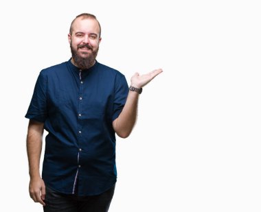 Genç beyaz hipster adam neşeli sunulması ve kameraya bakarak avucunun ile işaret gülümseyen izole arka plan.
