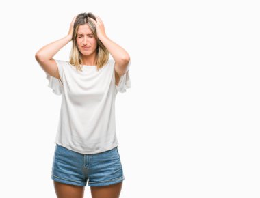 Genç ve güzel bir kadın, izole edilmiş arka planda acı ve migren yüzünden çaresiz ve stresli bir baş ağrısı çekiyor. Ellerini başının üstüne koy..