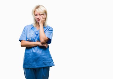 Düşünme izole arka plan bakmaktan Tıbbi üniforma giyen genç güzel sarışın doktor kadın yorgun ve sıkılmış çapraz silah depresyon sorunları ile.