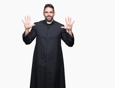 Genç Hıristiyan rahip gösterilen ve parmakları ile işaret izole arka plan üzerinde kendinden emin ve mutlu gülümseyerek süre on numara.