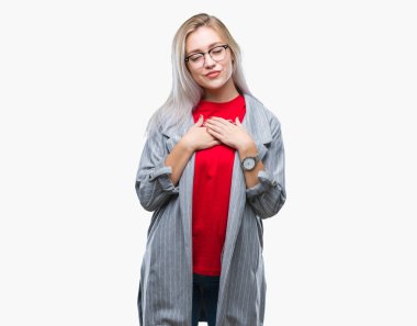 Üzerinde moda ceket giyen genç sarışın iş kadın kapalı gözler ile göğüs ellerinde ve yüzünde minnettar jest ile gülümseyen arka plan izole. Sağlık kavramı.