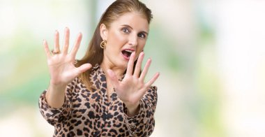 Üzerinde leopar elbise giyen güzel orta yaş olgun zengin kadın arka plan korkuyor ve korku ifade dur hareketi el ile ile dehşete şokta bağırarak izole. Panik kavramı.