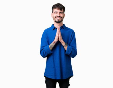 Yakışıklı delikanlı birlikte emin gülümseyen bağışlanmak ellerle dua izole arka plan üzerinde.