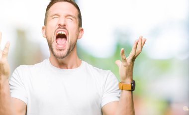 Yakışıklı adam kızgın ve silah ile başarı için deli kutluyor casual beyaz t-shirt giyen kaldırdı ve heyecanlı çığlık gözler kapalı. Kazanan kavramı