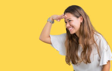 Genç güzel esmer iş kadını izole arka plan çok mutlu ve gülümseyen uzakta el ile üzerine kafa seyir üzerinde. Arama kavramı.