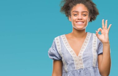 Gülümseyen izole arka plan üzerinde genç afro Amerikalı kadın el ve parmaklar ok işaretiyle yapıyor olumlu. Başarılı ifade.