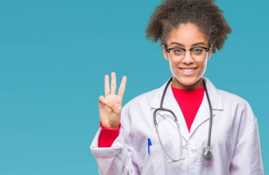 Genç afro Amerikalı doktor kadın gösterilen ve parmakları ile işaret izole arka plan yüzünden kendinden emin ve mutlu gülümseyerek iken üçüncü.