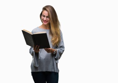 Genç güzel sarışın kadın ayakta ve diş gösterilen kendine güvenen bir gülümsemeyle gülümseyerek mutlu bir yüz ile izole arka plan üzerinde bir kitap okuma
