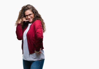 Ceket ve gözlük yapıyor gülümseyen izole arka plan üzerinde giyen güzel esmer kıvırcık saçlı Genç kız telefon hareketi ile el ve parmak telefonda konuşuyor gibi. Kavramları iletişim.