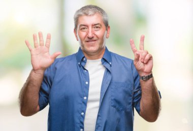 Üst düzey yakışıklı gösteren ve parmakları ile işaret izole arka plan üzerinde kendinden emin ve mutlu gülümseyerek süre yedi numara.