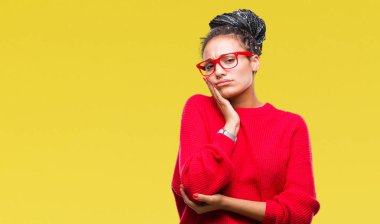 Genç örgülü saç Afro-Amerikan Kız giyiyor kazak ve gözlük seyir yorgun ve bıkkın ile depresyon sorun Çapraz kollar ile izole arka plan düşünme üzerinde.