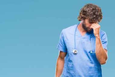 İzole arka burun ve göz yorgunluğu ve baş ağrısı duygu sürtünme yorgun yakışıklı İspanyol cerrah doktor adam. Stres ve hayal kırıklığı kavramı.