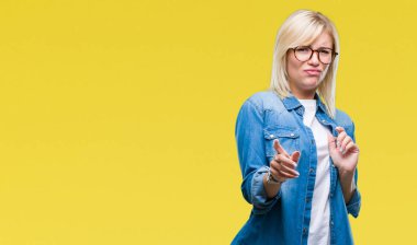 Genç güzel sarışın kadın izole arka plan üzerinde gözlük tiksinti ifadesi, memnun ve korkulu tiksinti yüz yapıyorsun çünkü nefret tepki. Elleriyle kaldırdı. Sinir bozucu kavramı.