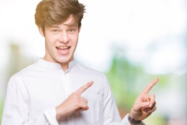 Genç yakışıklı iş adamı gülümseyen ve iki elleri ve parmakları ile tarafına işaret kamera bakarak izole arka plan üzerinde.