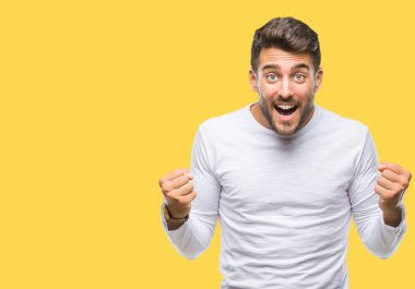 İzole arka plan kutlama üzerinde genç yakışıklı adam şaşırttı ve başarı için kaldırdı kollarını açarak hayret ve gözleri açık. Kazanan kavramı.