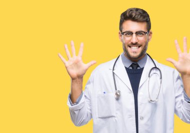 Genç yakışıklı Doktor adam gösterilen ve parmakları ile işaret izole arka plan üzerinde kendinden emin ve mutlu gülümseyerek süre on numara.