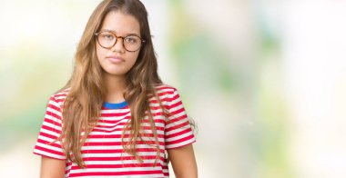 Giyen genç güzel esmer kadın gözlük ve t-shirt yüzünde ciddi bir ifade ile izole arka plan üzerinde çizgili. Basit ve doğal kameraya bakıyor.