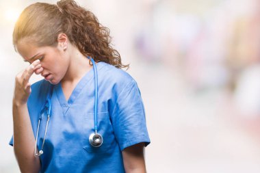 İzole arka plan üzerinde yorgun gözleri duygu yorgunluk ve baş ağrısı ve burun sürtme hemşire ya da cerrah üniforma giyen genç esmer doktor kız. Stres ve hayal kırıklığı kavramı.