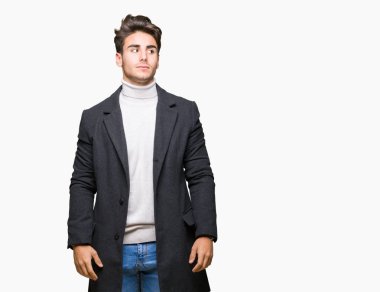 Zarif delikanlı görünümlü yan ve dik dik bakma uzağa düşünce gülümseyen izole arka plan üzerinde kış palto giyiyor.