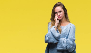 Kazak ve gözlük seyir yorgun ve bıkkın ile depresyon sorun Çapraz kollar ile izole arka plan düşünme üzerinde giyen genç güzel sarışın kadın.