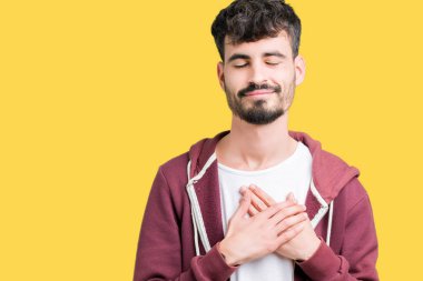 Yakışıklı delikanlı ile gülümseyen izole arka plan üzerinde kapalı gözler ve yüzünde minnettar jest ile göğüs üzerinde eller. Sağlık kavramı.