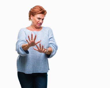 İzole arka plan üzerinde kış kazak giyen Atrractive üst düzey beyaz Kızıl saçlı kadın tiksinti ifadesi, memnun ve korkulu tiksinti yüz yapıyorsun çünkü nefret tepki. Elleriyle kaldırdı. Sinir bozucu kavramı.