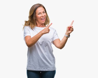 Orta yaş üst düzey İspanyol kadın gülümseyerek ve iki elleri ve parmakları ile tarafına işaret kamera bakarak izole arka plan.