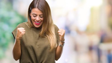 Gülümseyen ve başarı için çığlık genç güzel kadın izole arka plan çok mutlu ve heyecanlı kaldırdı, silah ile kazanan jest yapıyor. Kutlama kavramı.