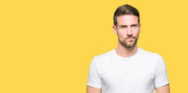 Casual beyaz t-shirt şüpheci ve sinir, papatyanın üzgün sorunu nedeniyle giyen yakışıklı adam. Negatif kişi.