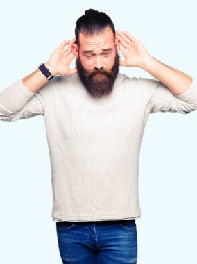 Kulak jest, dedikodu için meraklı her iki ellerde dinliyoruz rahat kazak giyen genç sarışın adam. İşitme sorunu, sağır