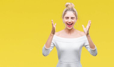 Genç güzel sarışın ve mavi gözlü kadın yüzünden kızgın kutluyor arka plan izole ve yükseltilmiş ve kapalı gözleri çığlık çılgın silah ile başarı için heyecanlı. Kazanan kavramı