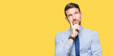 Yakışıklı iş adamı çene düşünme hakkında soru, dalgın ifade üzerine el ile kravat takıyor. Düşünceli yüzüyle gülümsüyor. Şüphe kavramı.