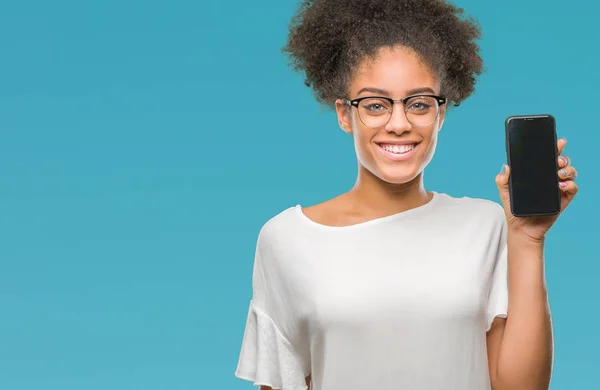 年轻美丽的非洲裔美国人显示智能手机屏幕在孤立的背景与幸福的脸站在和一个自信的微笑显示牙齿 — 图库照片