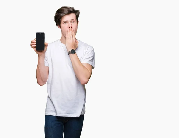 Молодой Человек Показывающий Экран Смартфона Изолированном Заднем Плане Прикрывает Рот — стоковое фото