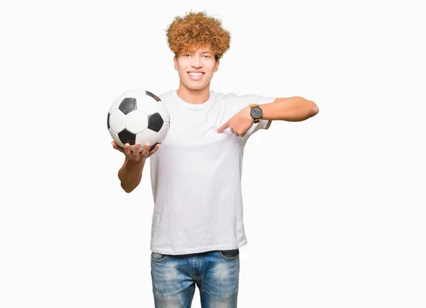 Joven Hombre Guapo Sosteniendo Pelota Fútbol Con Cara Sorpresa Señalando — Foto de Stock