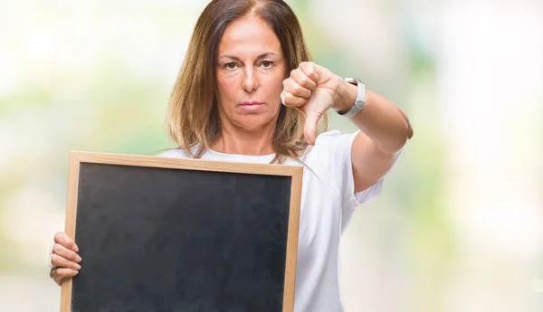 中年西班牙妇女拿着黑板在孤立的背景与愤怒的脸 负面的迹象显示不喜欢大拇指下来 拒绝的概念 — 图库照片