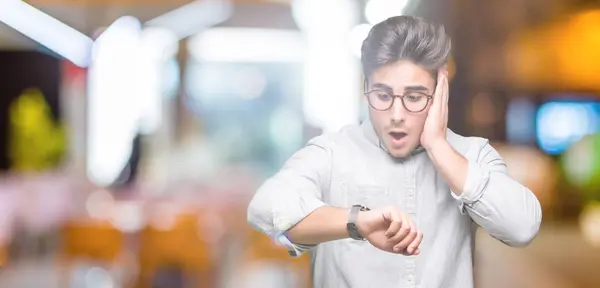 Joven Hombre Guapo Con Gafas Sobre Fondo Aislado Mirando Tiempo —  Fotos de Stock