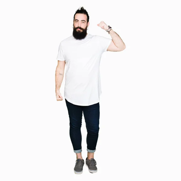 年轻的嬉皮士男子长头发和胡子穿着休闲的白色 T恤坚强的人表现出手臂肌肉 自信和自豪的力量 — 图库照片
