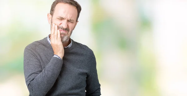 歯痛や歯の歯科病気のため痛みを伴う式で手で口に触れて分離の背景の上にセーターを着ているハンサムな中年年配の男性 歯医者コンセプト — ストック写真