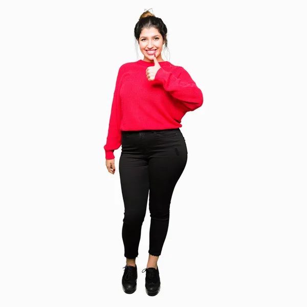 Młoda Piękna Kobieta Sobie Czerwony Sweter Bun Robi Szczęśliwy Kciuk — Zdjęcie stockowe