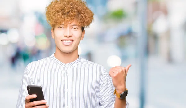 Ung Vacker Man Med Smartphone Pekar Och Visar Med Tumme — Stockfoto