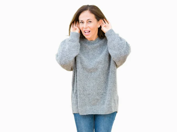 美丽的中年妇女穿着冬天的毛衣在孤立的背景试图听到双手对耳朵的手势 好奇八卦 听力问题 — 图库照片