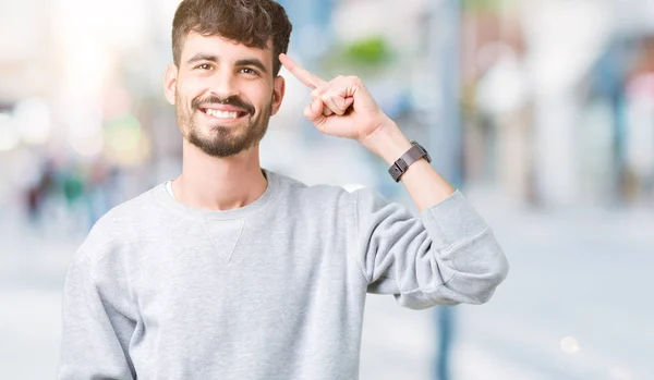 Joven Hombre Guapo Usando Sudadera Sobre Fondo Aislado Sonriendo Señalando —  Fotos de Stock