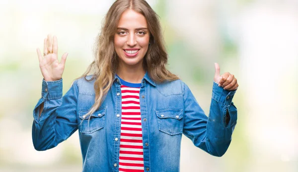 Beautiful young blonde woman over isolated background showing and pointing up with fingers number six while smiling confident and happy.