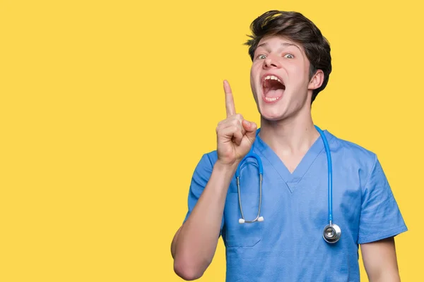 年轻的医生穿着医疗制服在孤立的背景指向手指与成功的想法 离开和快乐 — 图库照片