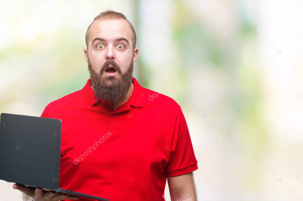 Young caucasian man using computer laptop over isolated background scared in shock with a surprise face, afraid and excited with fear expression