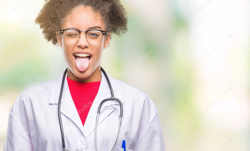 Young afro american doctor woman over isolated background sticking tongue out happy with funny expression. Emotion concept.