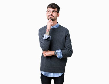 Genç yakışıklı çene düşünme hakkında soru, dalgın ifade üzerine el ile izole arka plan üzerinde gözlük takan adam akıllı. Düşünceli yüzüyle gülümsüyor. Şüphe kavramı.
