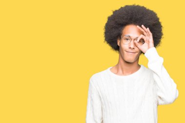 Afrikalı-Amerikalı genç afro saçlı gözlüklü gülümseyen, parmakları ile mutlu yüz üzerinden seyir göz el ile ok jest yapıyor.