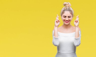 Genç güzel sarışın ve mavi gözlü kadın geçiş parmakları umut ve gözler gülümseyen izole arka plan yüzünden kapalı. Şans ve batıl kavramı.